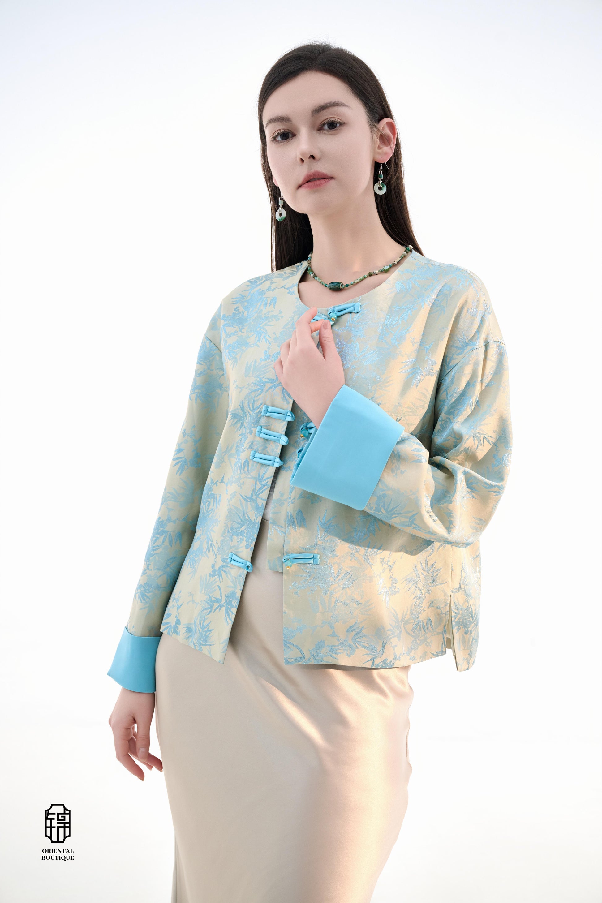 Bamboo Shadow Satin Long-Sleeve Top with Blue Knots,This Bamboo Shadow Satin Long-Sleeve Top features a graceful combination of light blue and beige with a subtle bamboo print. The design is accentuated by traditional Chinese blue knotted buttons and matc