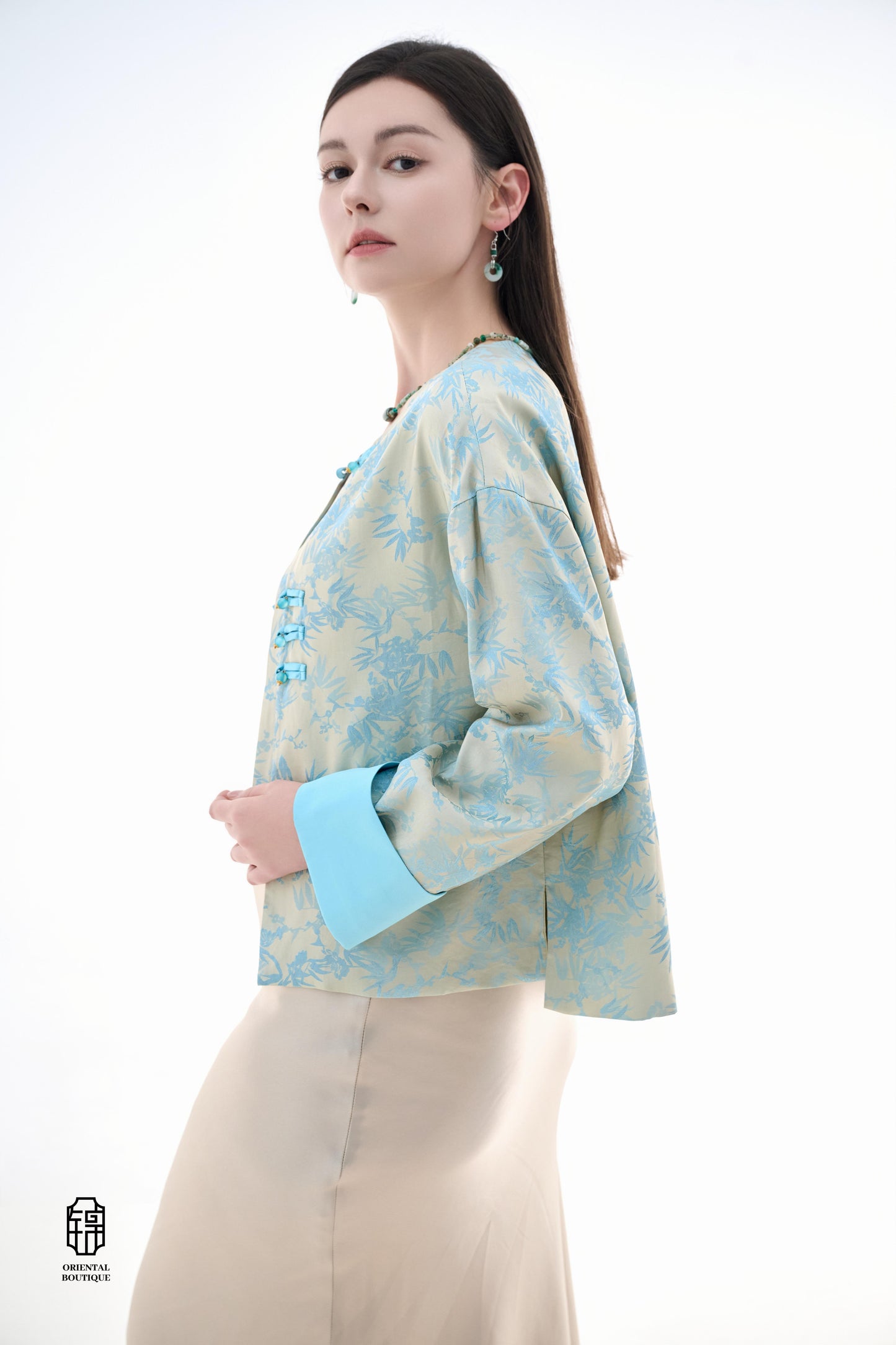 Bamboo Shadow Satin Long-Sleeve Top with Blue Knots,This Bamboo Shadow Satin Long-Sleeve Top features a graceful combination of light blue and beige with a subtle bamboo print. The design is accentuated by traditional Chinese blue knotted buttons and matc