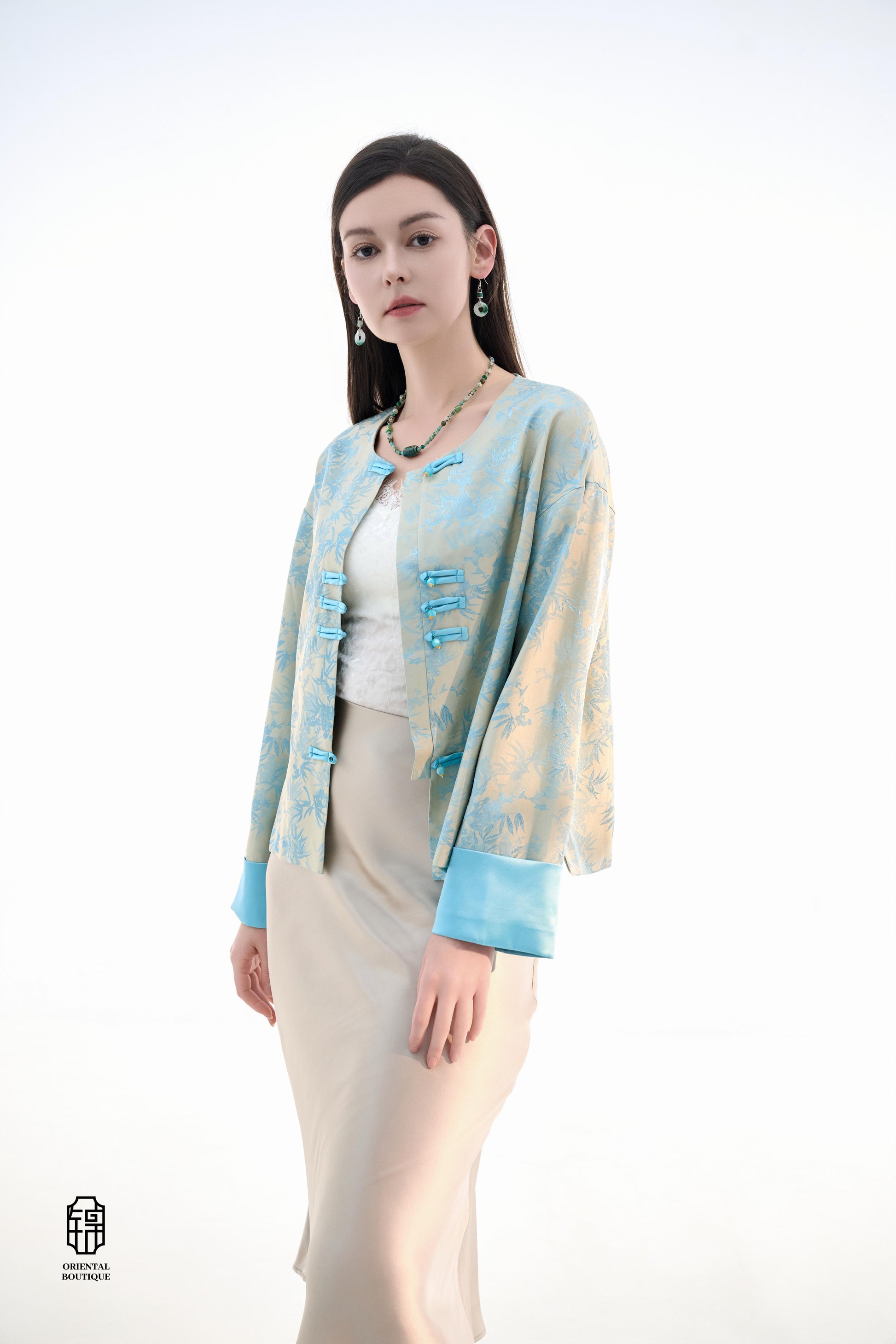 Bamboo Shadow Satin Long-Sleeve Top with Blue Knots,This Bamboo Shadow Satin Long-Sleeve Top features a graceful combination of light blue and beige with a subtle bamboo print. The design is accentuated by traditional Chinese blue knotted buttons and matc