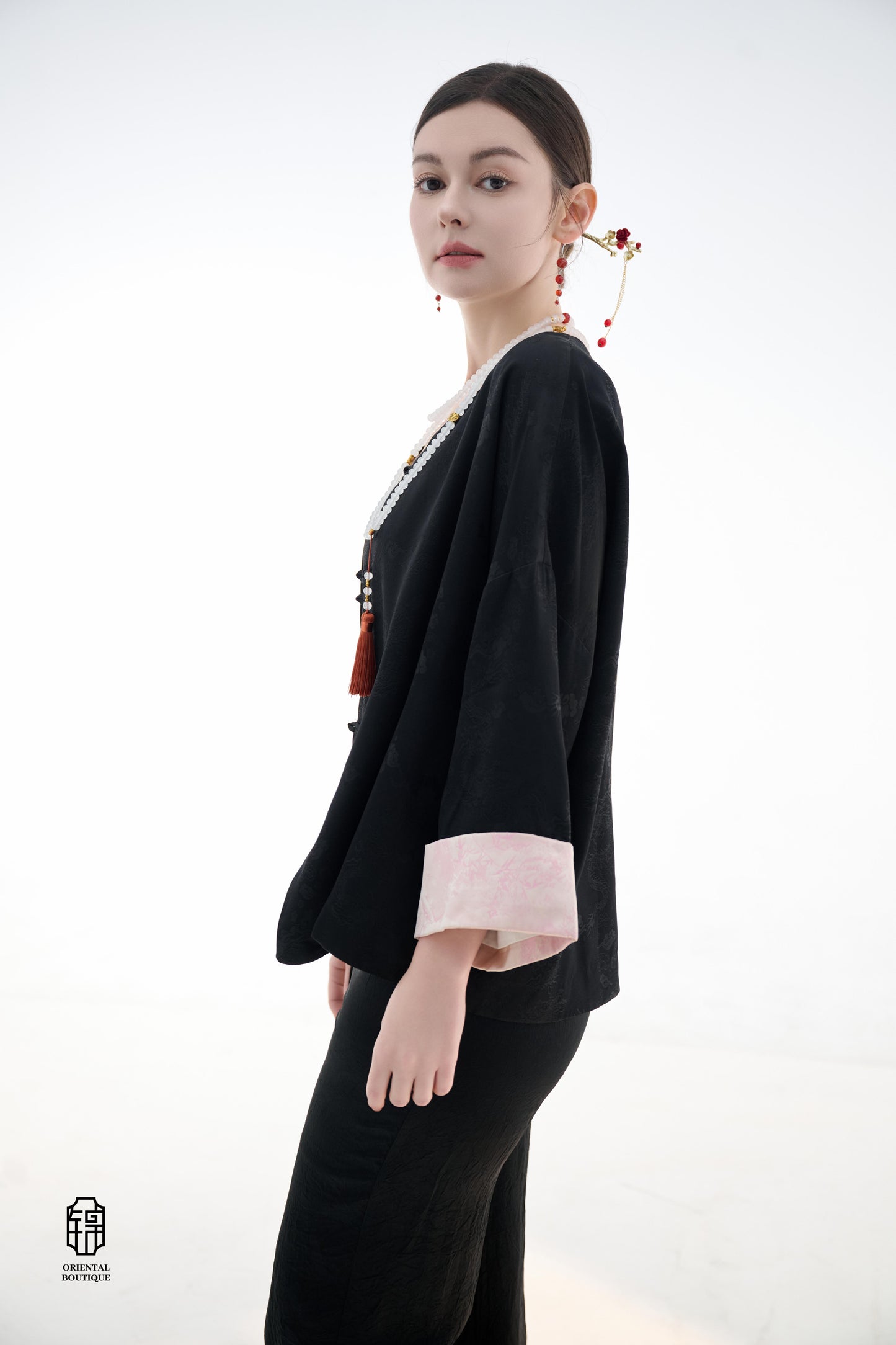 Elegant Jade-Embellished Jacket,The Elegant Jade-Embellished Jacket features a sleek black design with a minimalist yet sophisticated touch. The jacket is adorned with several delicate jade buttons, symbolizing grace and luxury. Its loose fit and soft fab