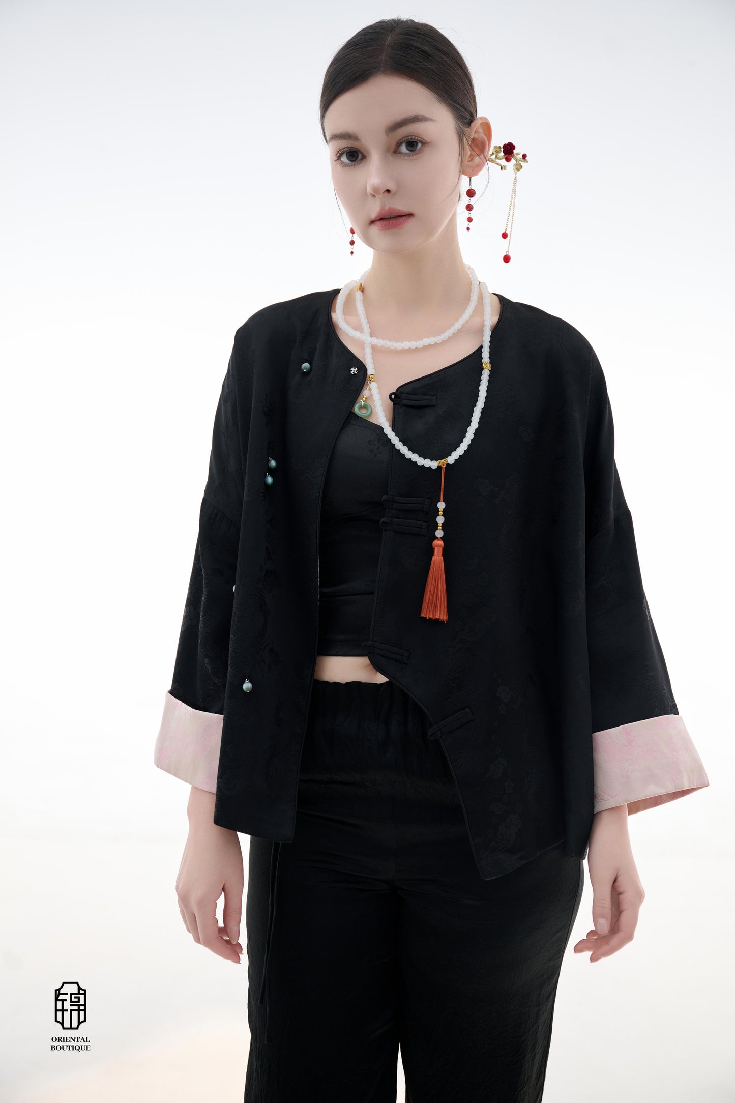 Elegant Jade-Embellished Jacket,The Elegant Jade-Embellished Jacket features a sleek black design with a minimalist yet sophisticated touch. The jacket is adorned with several delicate jade buttons, symbolizing grace and luxury. Its loose fit and soft fab