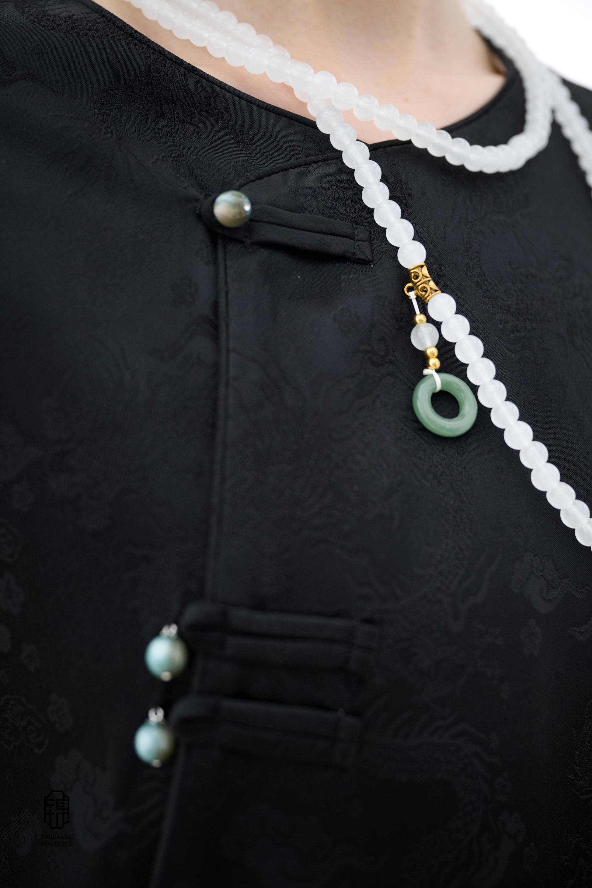 Elegant Jade-Embellished Jacket,The Elegant Jade-Embellished Jacket features a sleek black design with a minimalist yet sophisticated touch. The jacket is adorned with several delicate jade buttons, symbolizing grace and luxury. Its loose fit and soft fab