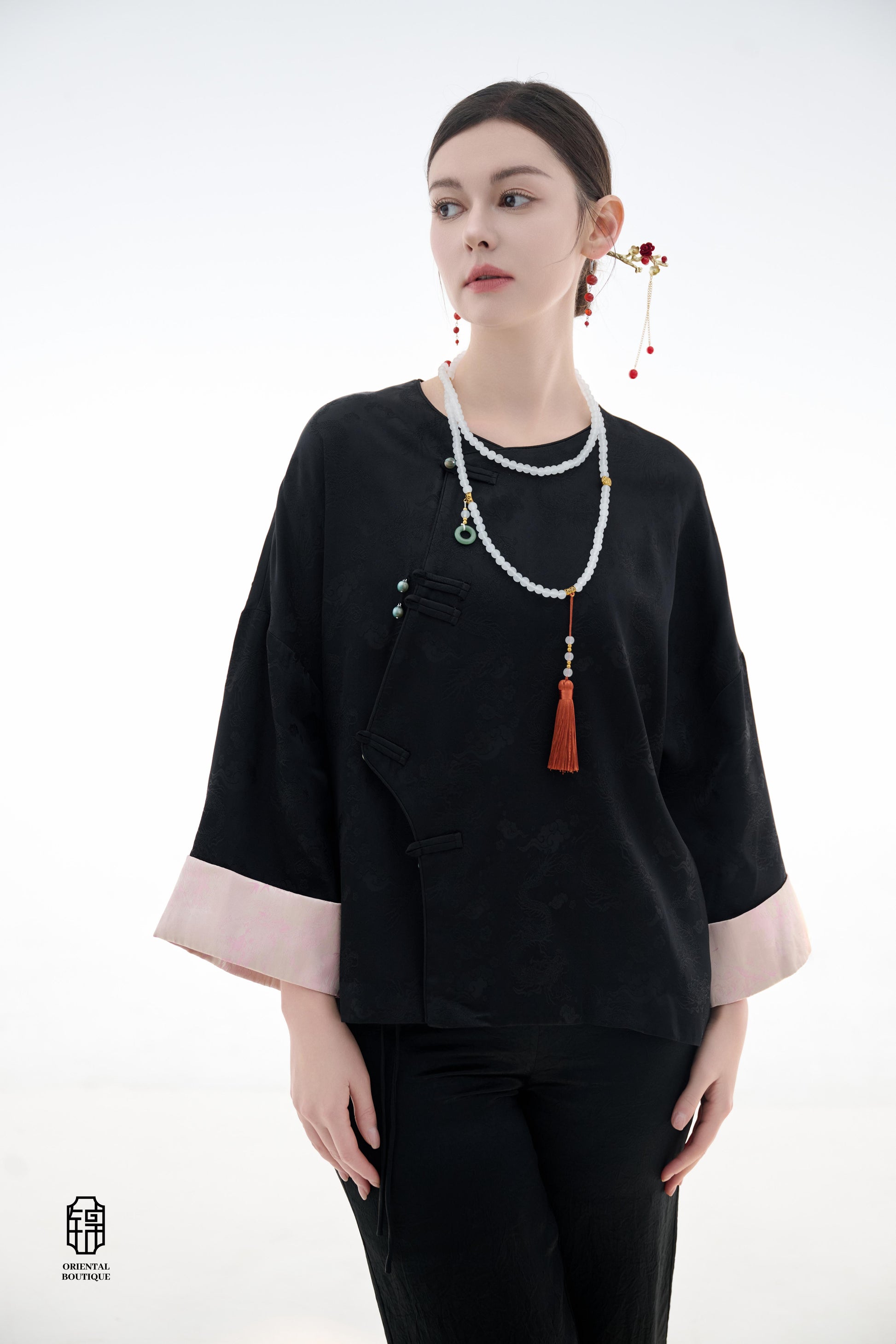 Elegant Jade-Embellished Jacket,The Elegant Jade-Embellished Jacket features a sleek black design with a minimalist yet sophisticated touch. The jacket is adorned with several delicate jade buttons, symbolizing grace and luxury. Its loose fit and soft fab