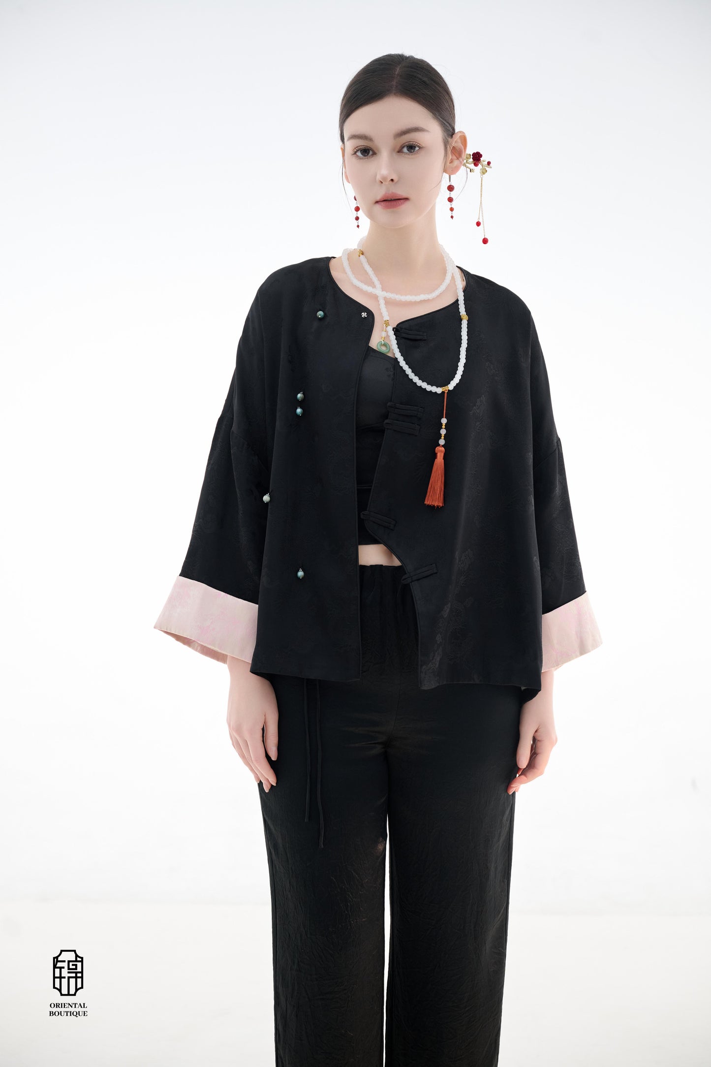 Elegant Jade-Embellished Jacket,The Elegant Jade-Embellished Jacket features a sleek black design with a minimalist yet sophisticated touch. The jacket is adorned with several delicate jade buttons, symbolizing grace and luxury. Its loose fit and soft fab