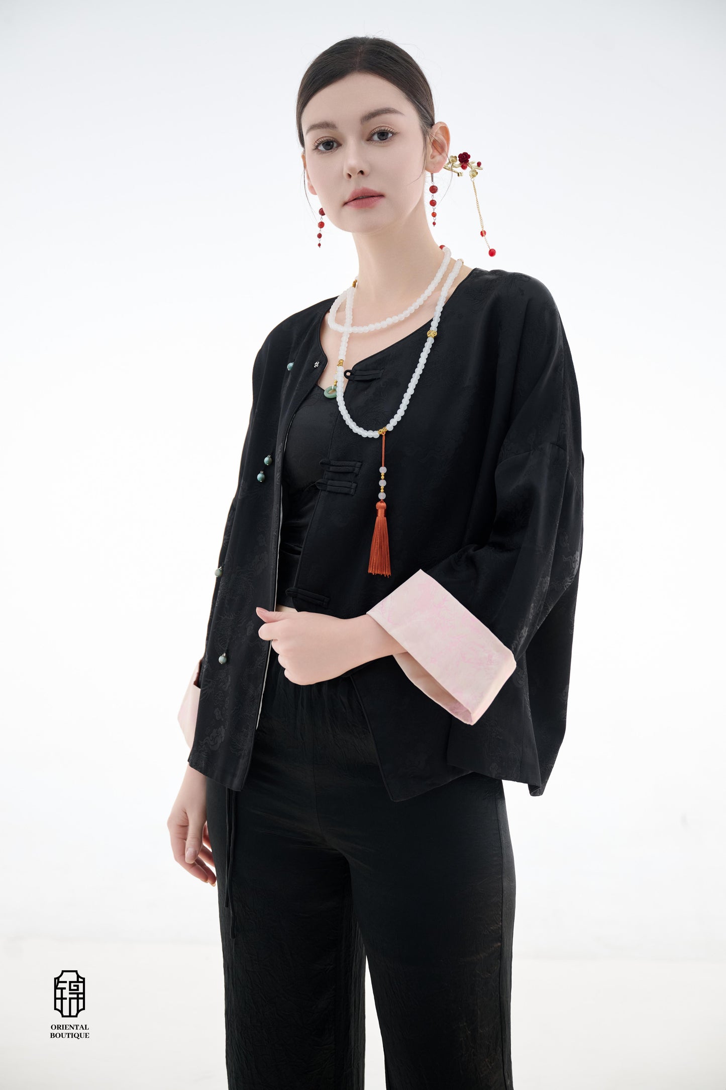 Elegant Jade-Embellished Jacket,The Elegant Jade-Embellished Jacket features a sleek black design with a minimalist yet sophisticated touch. The jacket is adorned with several delicate jade buttons, symbolizing grace and luxury. Its loose fit and soft fab