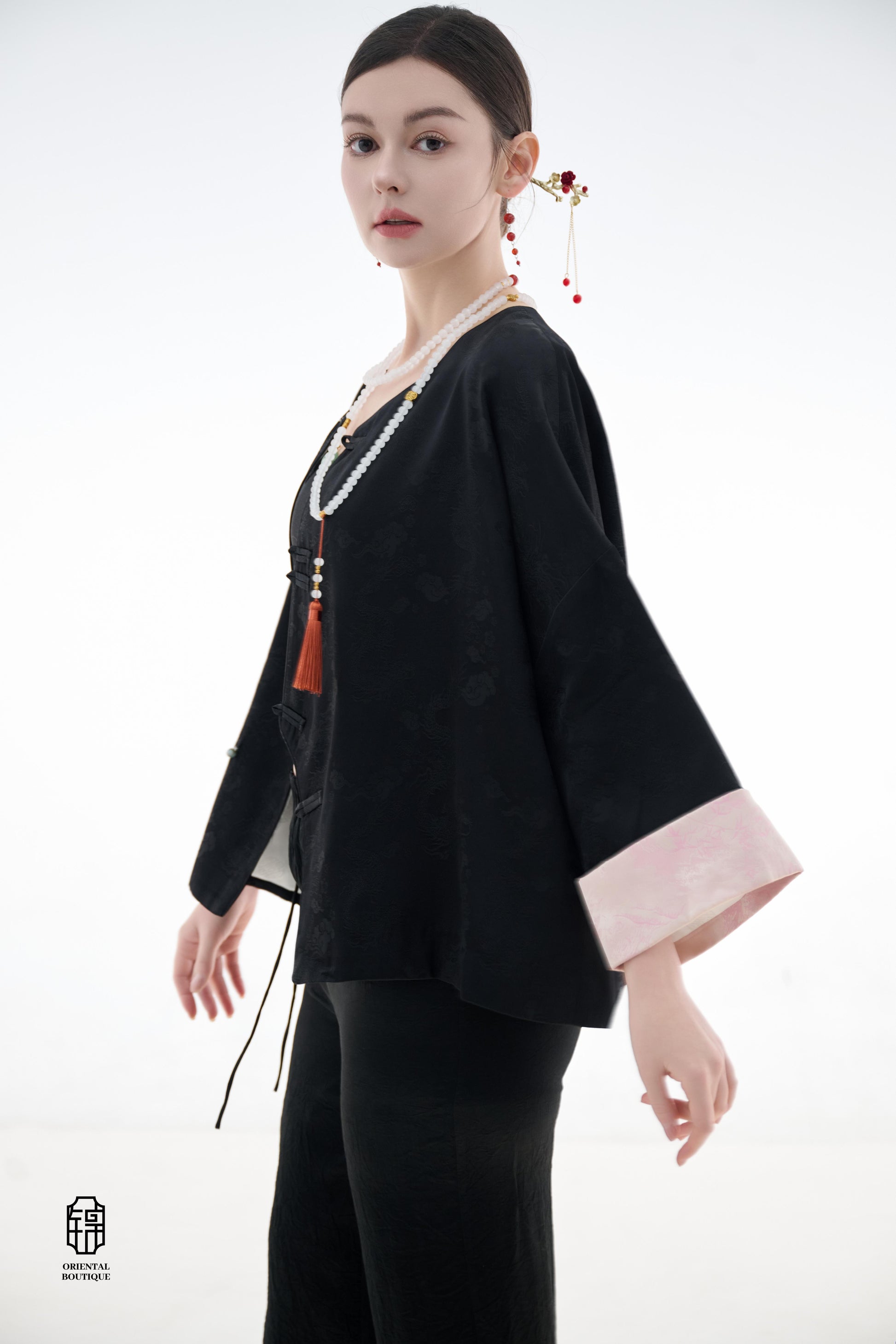 Elegant Jade-Embellished Jacket,The Elegant Jade-Embellished Jacket features a sleek black design with a minimalist yet sophisticated touch. The jacket is adorned with several delicate jade buttons, symbolizing grace and luxury. Its loose fit and soft fab