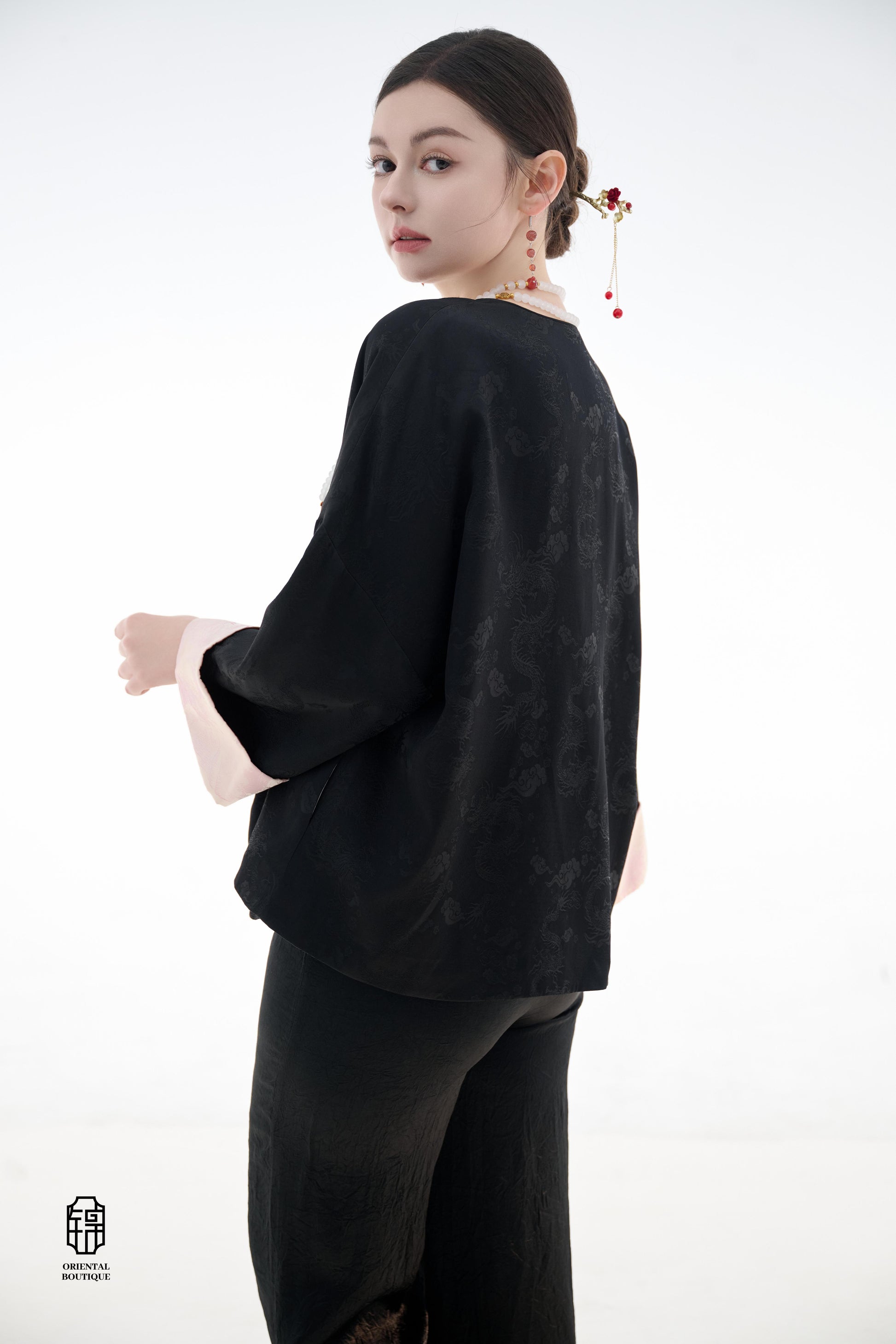 Elegant Jade-Embellished Jacket,The Elegant Jade-Embellished Jacket features a sleek black design with a minimalist yet sophisticated touch. The jacket is adorned with several delicate jade buttons, symbolizing grace and luxury. Its loose fit and soft fab