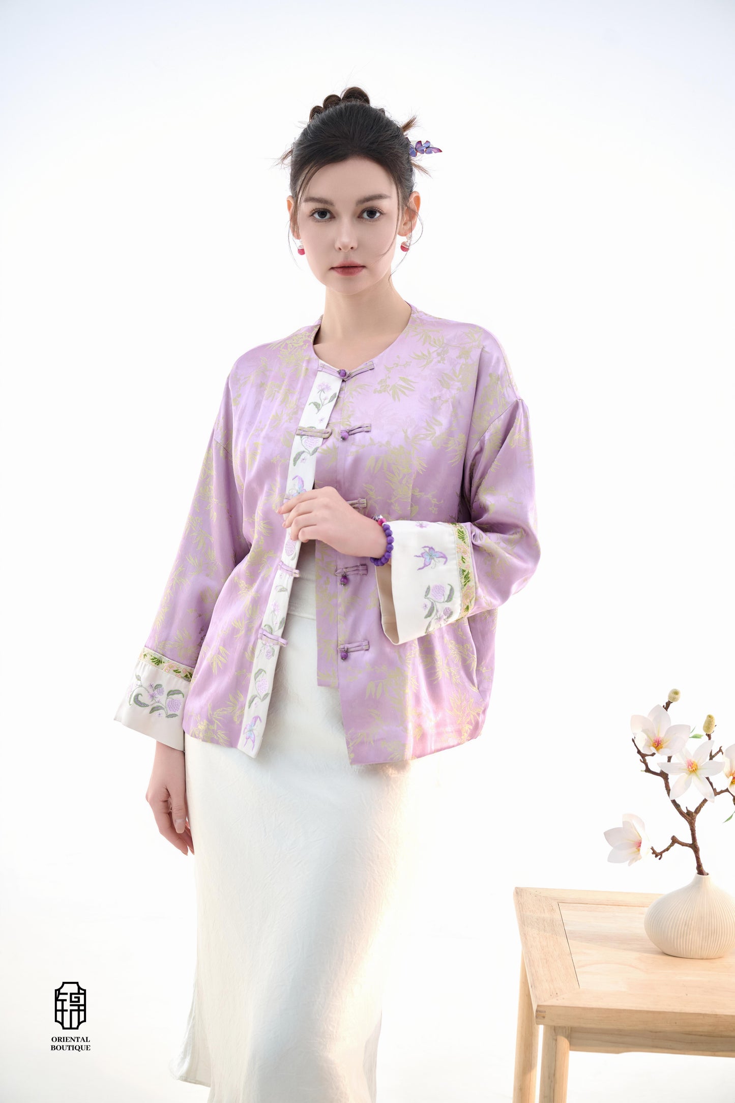 Lavender Bamboo Grace Jacket,The Lavender Bamboo Grace Jacket is made from soft lavender silk fabric, delicately embroidered with bamboo leaf patterns that evoke freshness and elegance. The cuffs and collar are lined with floral accents, adding a layer of