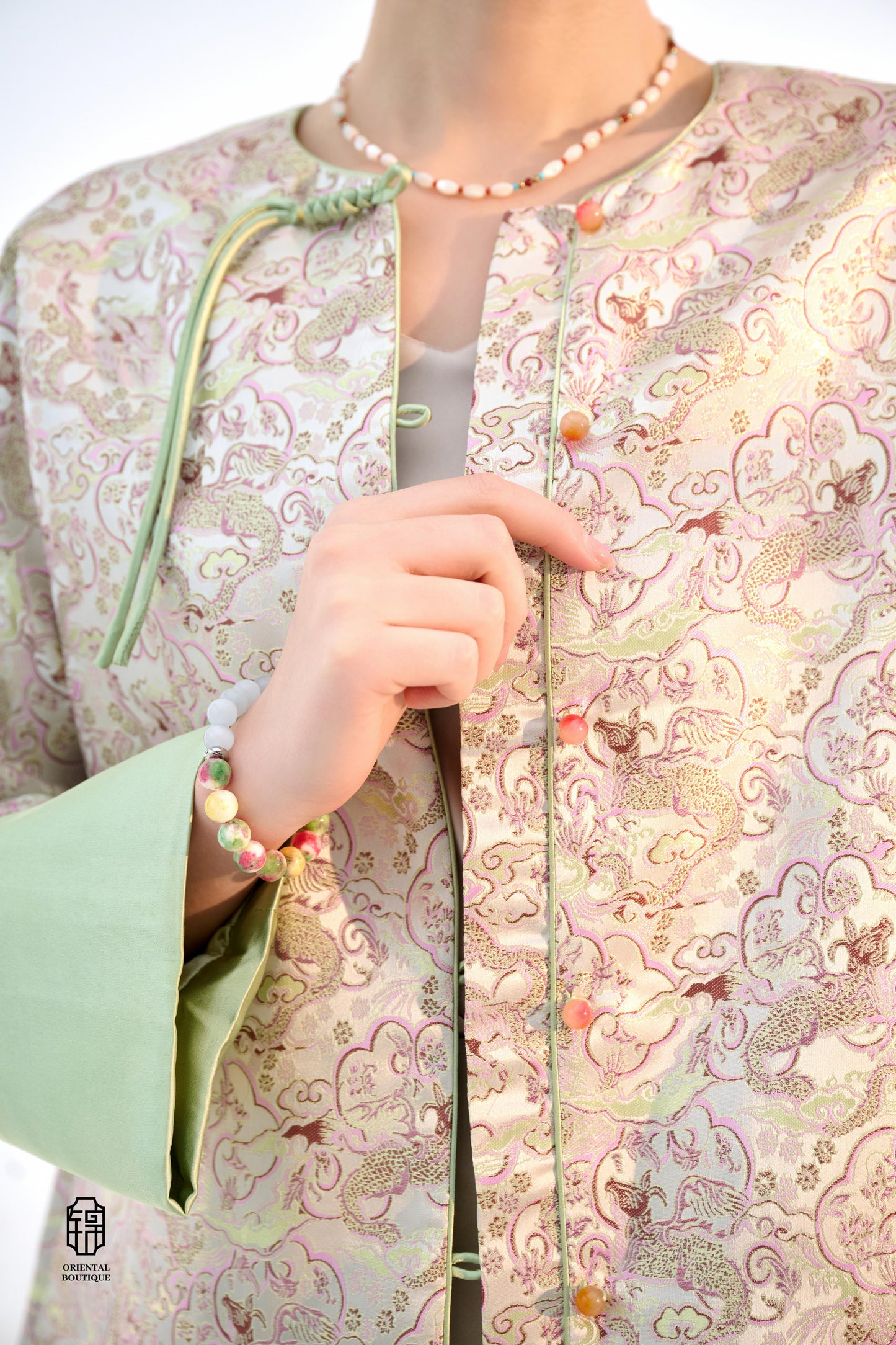 Emerald Blossom Brocade Jacket,The Emerald Blossom Brocade Jacket is crafted from light silk fabric, featuring a refined and elegant design. The jacket is adorned with intricate floral patterns, reminiscent of a sea of blossoms, highlighting the delicate