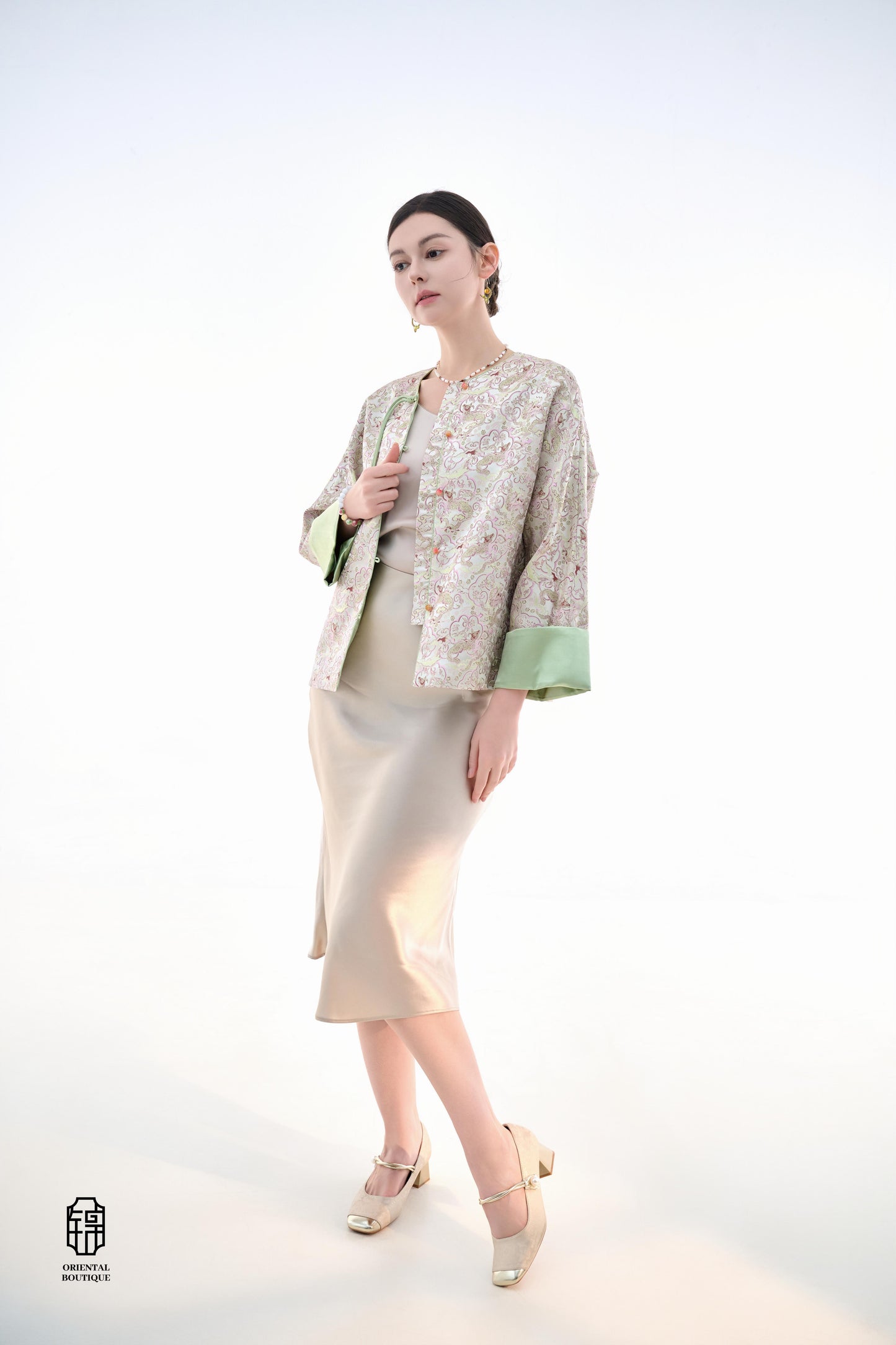 Emerald Blossom Brocade Jacket,The Emerald Blossom Brocade Jacket is crafted from light silk fabric, featuring a refined and elegant design. The jacket is adorned with intricate floral patterns, reminiscent of a sea of blossoms, highlighting the delicate