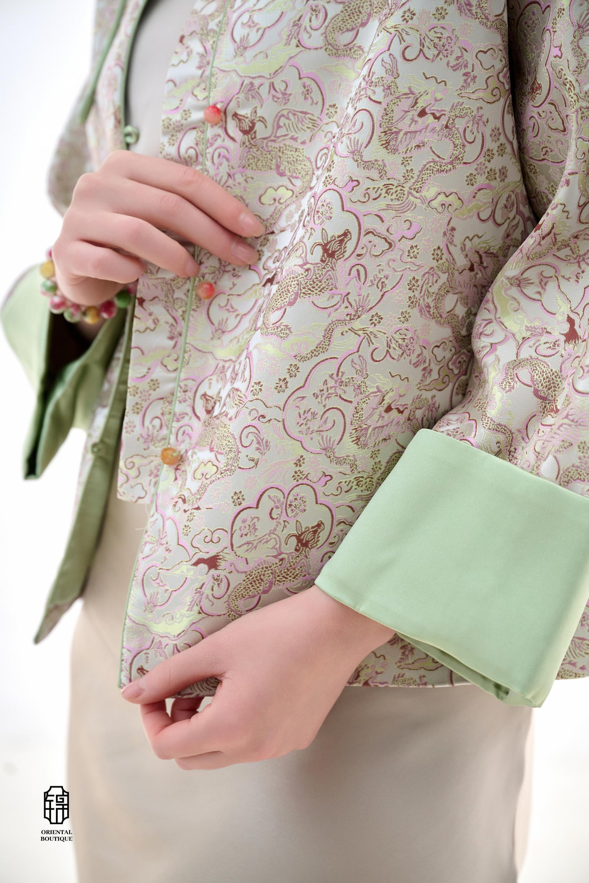 Emerald Blossom Brocade Jacket,The Emerald Blossom Brocade Jacket is crafted from light silk fabric, featuring a refined and elegant design. The jacket is adorned with intricate floral patterns, reminiscent of a sea of blossoms, highlighting the delicate