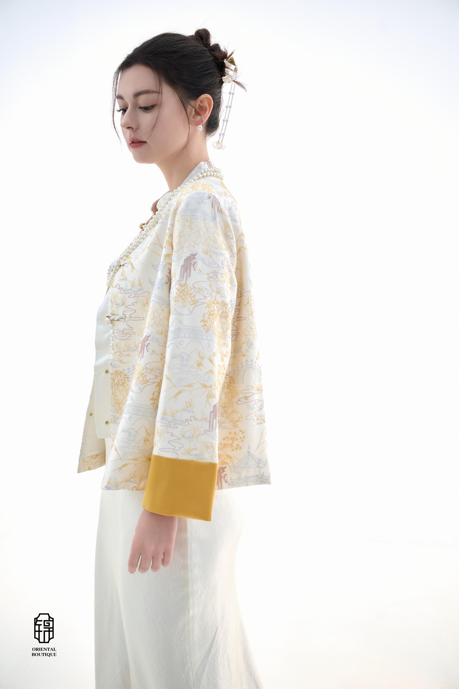 Scenic Brocade Jacket,The Scenic Brocade Jacket features intricate embroidered designs depicting traditional landscapes of mountains, pagodas, and natural scenery, showcasing an Oriental charm. With a base of soft ivory and accents of bright golden yellow