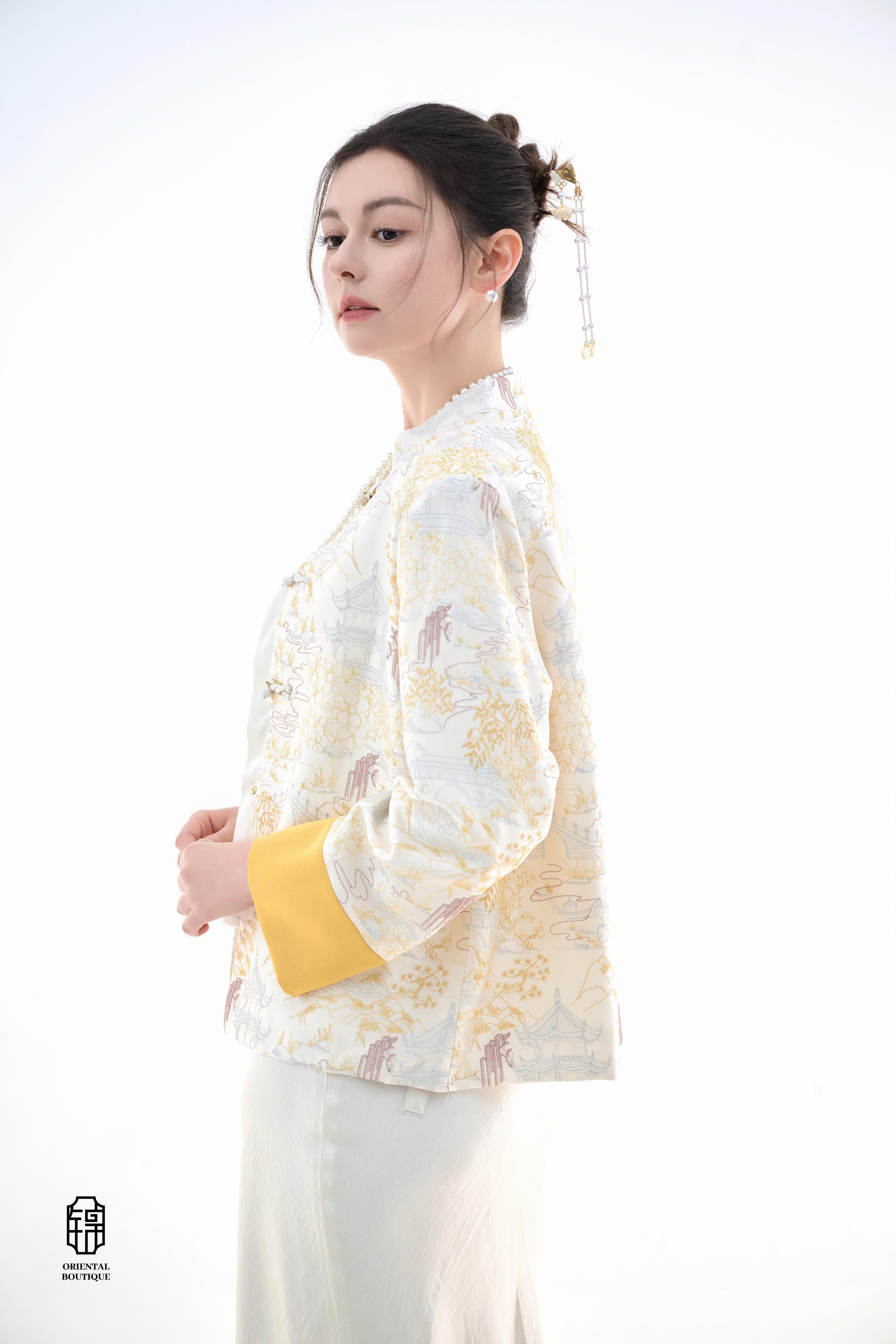 Scenic Brocade Jacket,The Scenic Brocade Jacket features intricate embroidered designs depicting traditional landscapes of mountains, pagodas, and natural scenery, showcasing an Oriental charm. With a base of soft ivory and accents of bright golden yellow