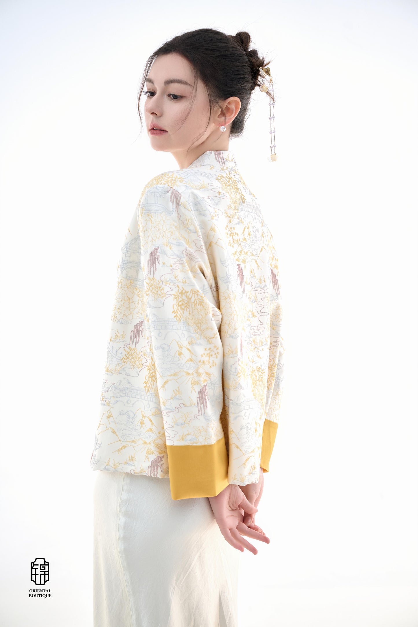 Scenic Brocade Jacket,The Scenic Brocade Jacket features intricate embroidered designs depicting traditional landscapes of mountains, pagodas, and natural scenery, showcasing an Oriental charm. With a base of soft ivory and accents of bright golden yellow
