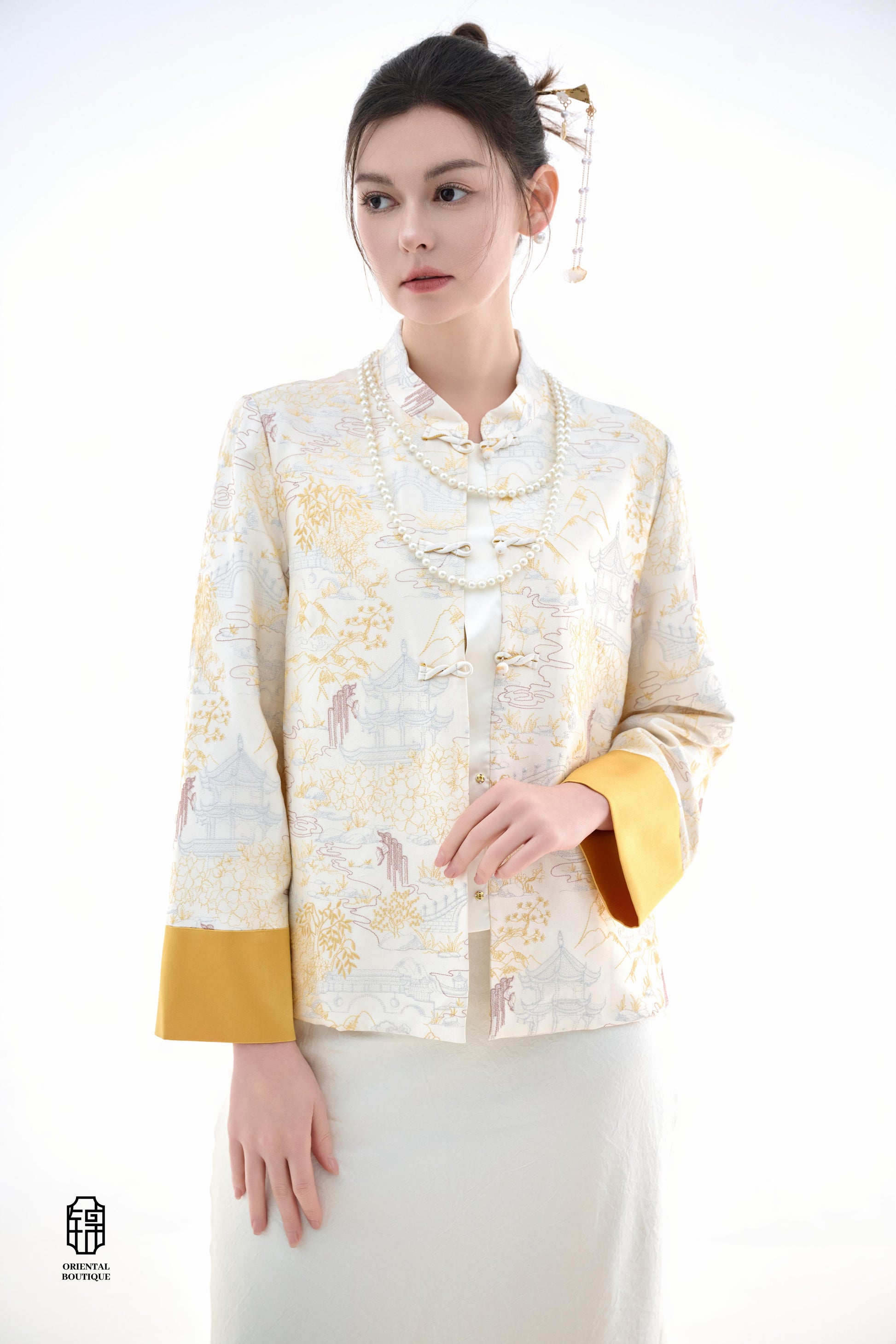 Scenic Brocade Jacket,The Scenic Brocade Jacket features intricate embroidered designs depicting traditional landscapes of mountains, pagodas, and natural scenery, showcasing an Oriental charm. With a base of soft ivory and accents of bright golden yellow