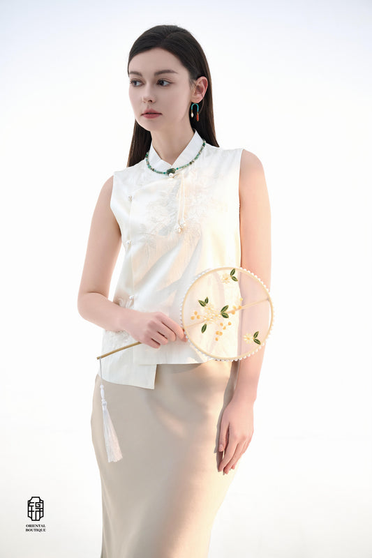 Magnolia Embroidered Sleeveless Mandarin Collar Top,This Magnolia Embroidered Sleeveless Mandarin Collar Top features a refined light hue, exuding freshness and elegance. The front is adorned with delicate magnolia embroidery, embodying the beauty and sop